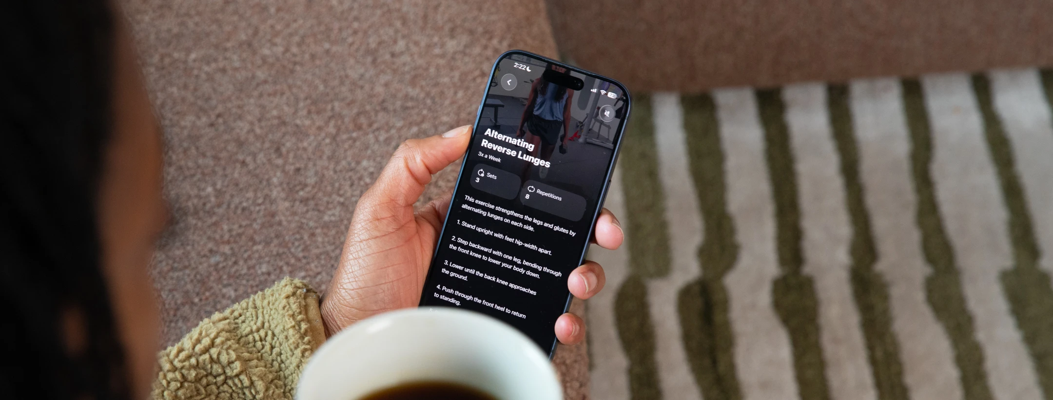 Athlete at home with coffee, following their program on their phone