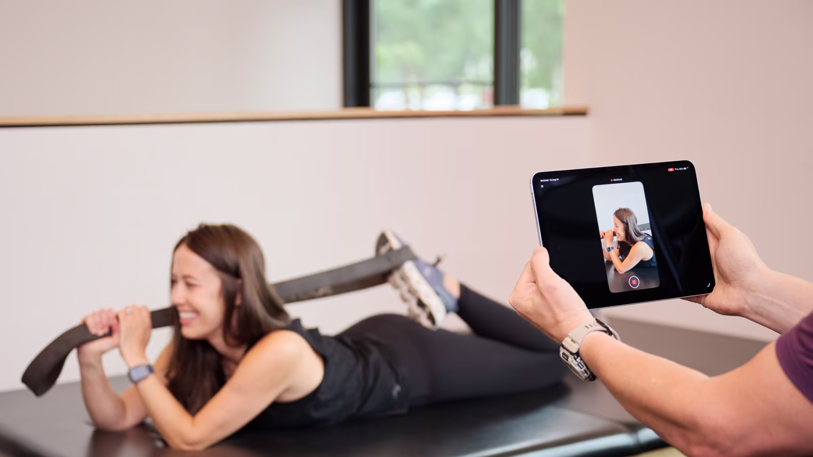 Clinician recording a patient performing an exercise during a visit